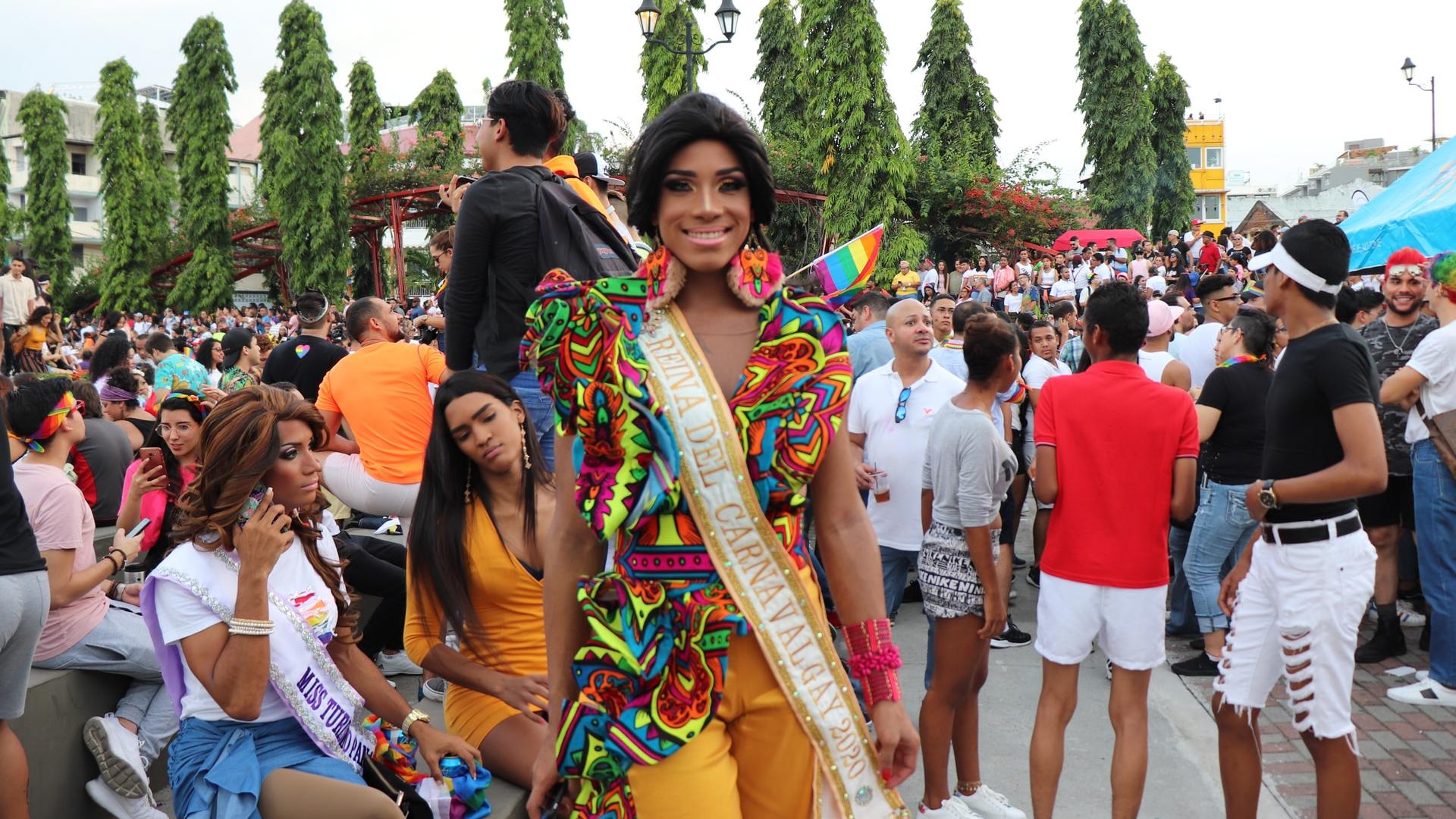 woman in red tank top and blue yellow and green scarf standing on the street